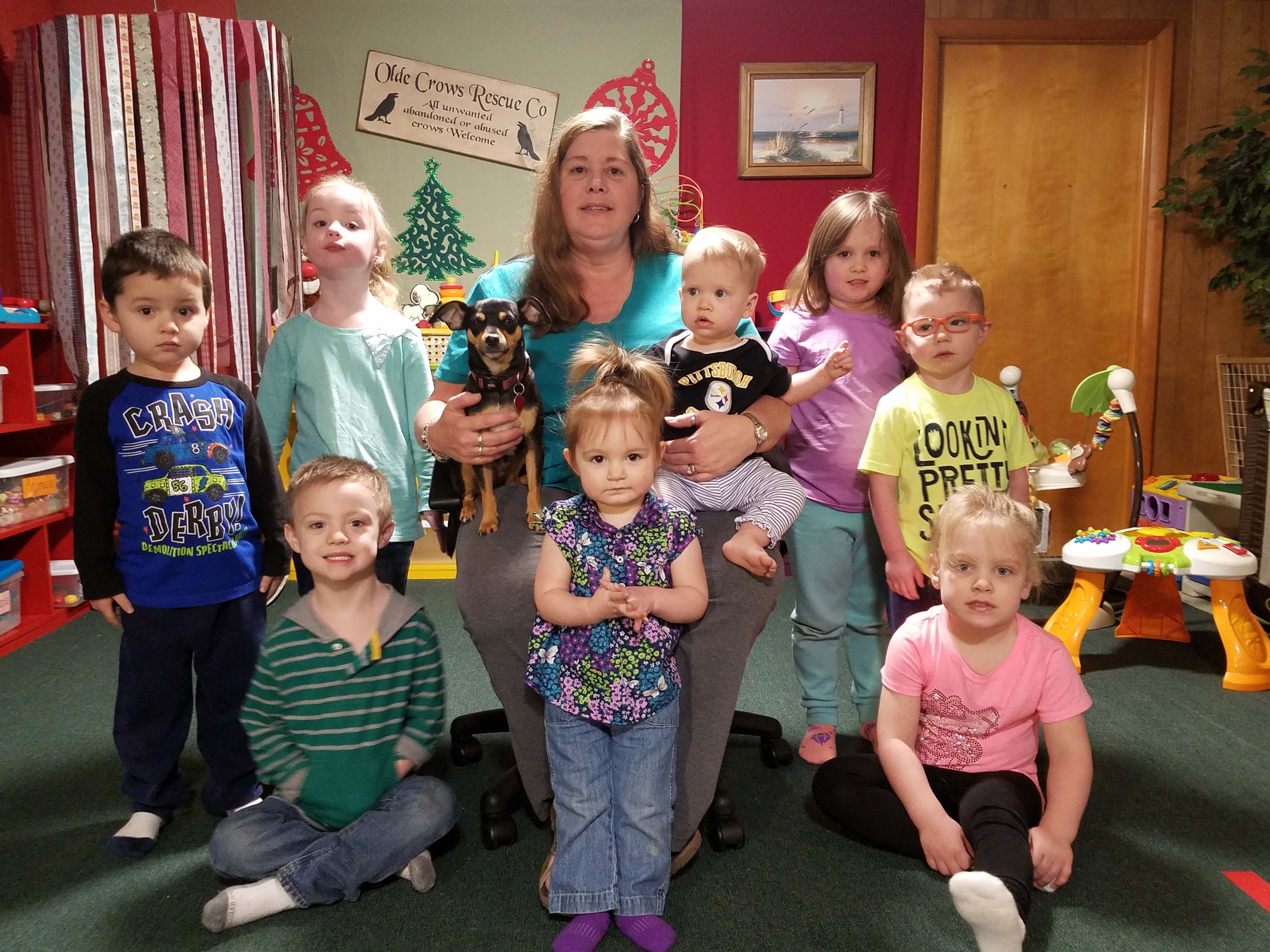 Nancy Rife in the center of a photo, surrounded by eight children under her care.