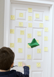 Sticky notes on a door for a child to play a game to identify letters for a game