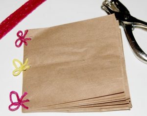 A scrapbook made from brown paper bags and tied together with yarn.