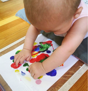 Baby doing a fingerpainting while having tummy time