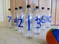 Clear, empty soda bottles arranged like bowling pins and painted with the numbers one through ten.