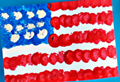 An American flag craft painted with cotton balls on construction paper