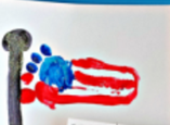 A child's footprint painted in the colors of the American flag