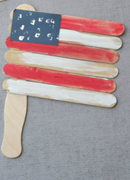 An American flag craft made from popsicle sticks and painted red, white, and blue