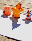 Three small toys placed on a sheet of paper to create shadows