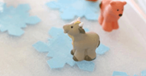 Two toy animals placed on light blue paper snowflakes