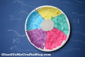 A multicolored beach ball craft made from a paper plate and tissue paper