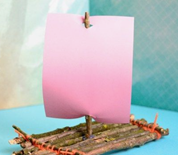 Toy boat made from twigs with a paper sail