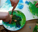 Child using a paintbrush made from a stick