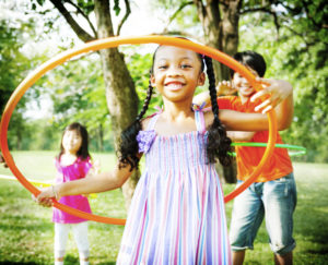Three children play with hula hoops